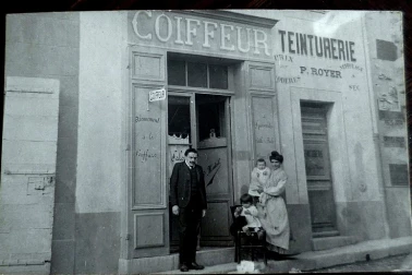 Magasin de salon de coiffure avec la petite famille devant la porte