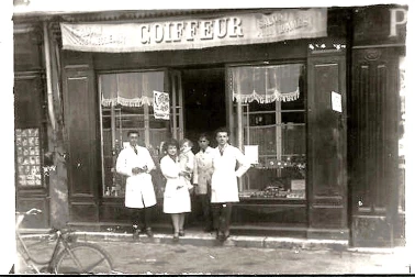 Le coiffeur devant son magasin avec ses employes