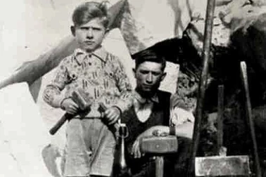 Un carrier pres de son fils montre ses outils en 1936